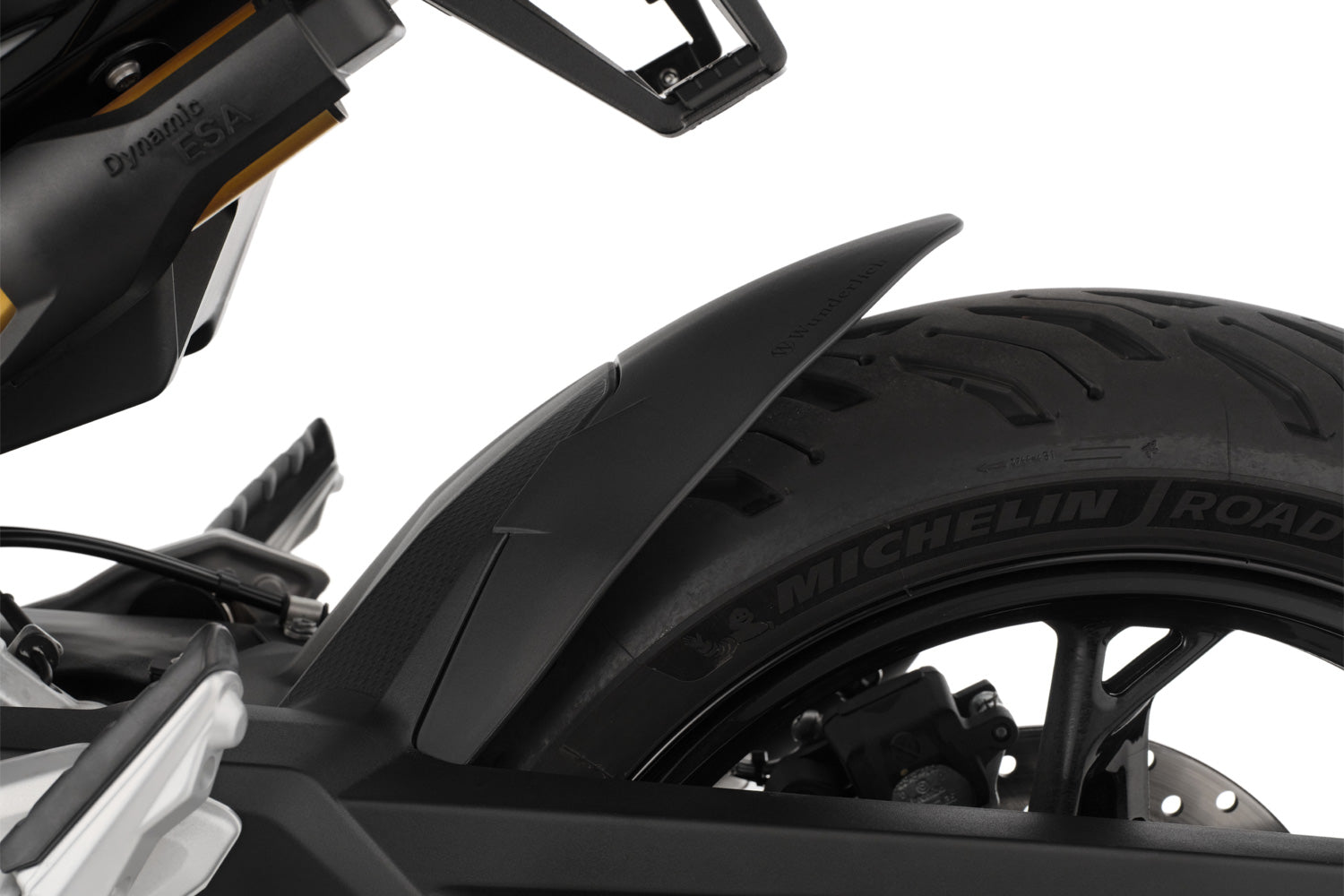 The area around the swing arm pivot, the swing arm, the collector, the gears and the shock absorber are in front of the rear wheel and thus