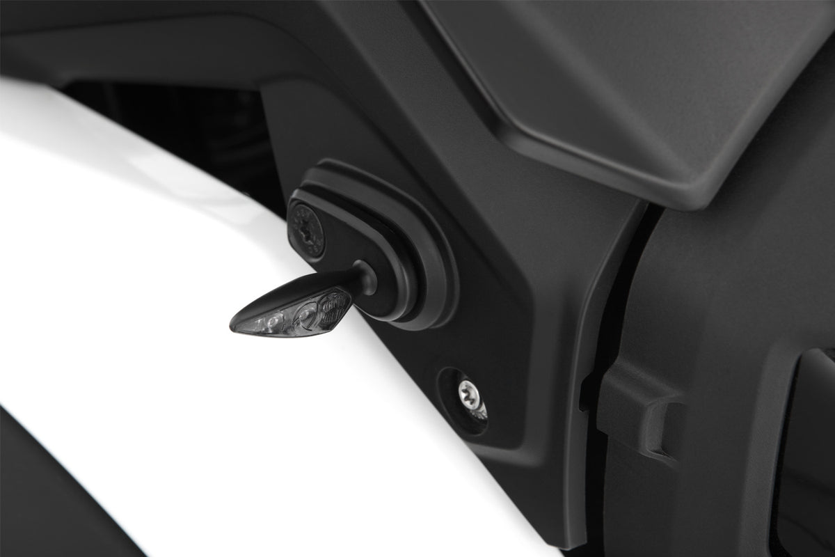 This adapter covers the opening on the original indicator bracket and simultaneously lets you attach accessory indicators.